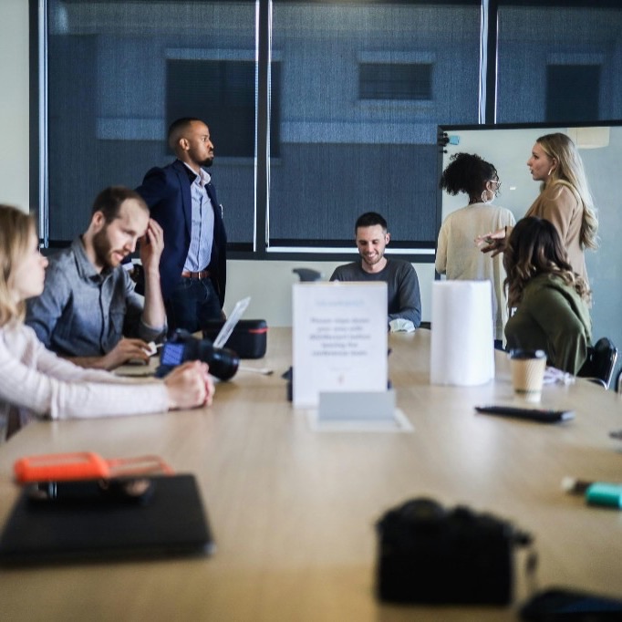 Team meeting in a bright office around a conference table, representing the start of a joint engagement.
